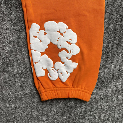 DENIM TEARS COTTON WREATH SWEATPANTS ORANGE - close up - replica sneakers